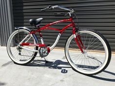 a red and white bicycle parked in front of a building