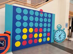 a large blue and yellow wall with clocks on it's sides in a building