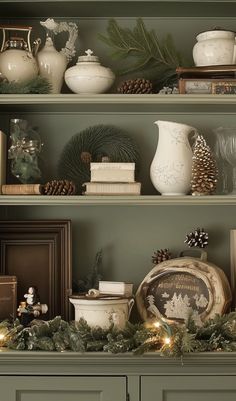 a shelf with christmas decorations and other items on it's top, including pine cones