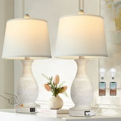 two white lamps sitting on top of a table