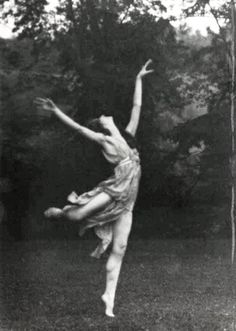 a black and white photo of a woman jumping in the air with her arms outstretched