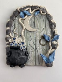 a ceramic wall hanging with an animal and moon on it