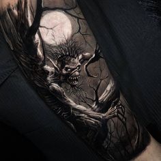 a man's arm with a creepy tree and moon tattoo on it