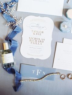 the wedding stationery is laid out with rings, ring boxes, and other items