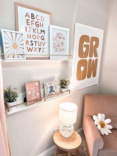 a living room with pictures on the wall and a lamp next to a chair in front of it