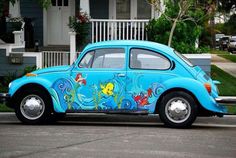 an old blue beetle painted with cartoon fish