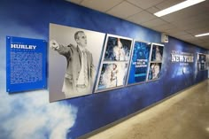 a hallway with blue walls and pictures on the wall, along with information about men's history