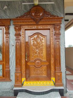 an ornate wooden door in front of a stone wall