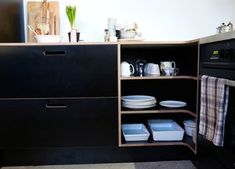 a kitchen with black cabinets and white dishes