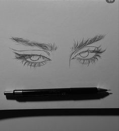 a pencil drawing of an eye with long lashes and eyelashes on top of the paper