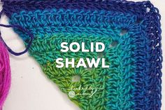 there is a crocheted triangle with the words solid shawl written across it