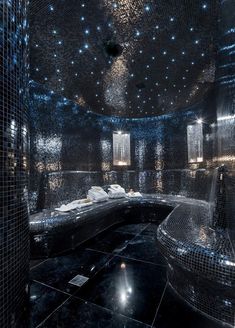 an artisticly designed bathroom with black and silver tiles