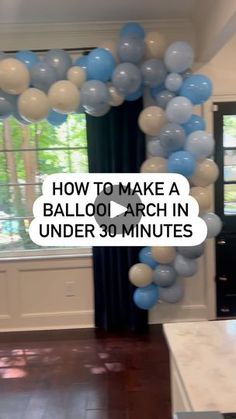 a balloon arch in the middle of a living room filled with blue and white balloons