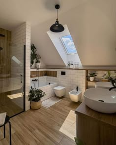 a bathroom with two sinks and a skylight in the ceiling, along with wooden flooring