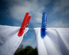 two red and blue clothes pins are hanging on the clothesline