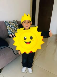 a young boy is holding up a cardboard sun