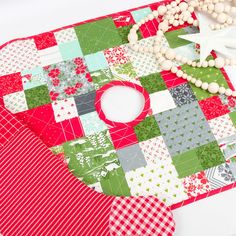 a red and green patchwork placemat with white beads on it next to a star