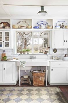 a kitchen with lots of white cupboards and cabinets in it's center island