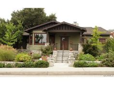 a house with landscaping in front of it and trees on the other side of the house