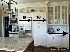 a kitchen with white cabinets and an island in front of the countertop has arrows pointing to different areas