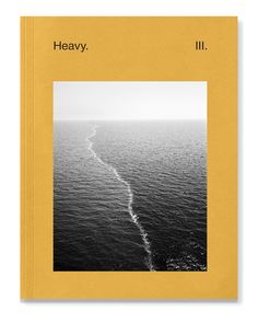 a book with an image of the ocean in black and white, on top of a yellow cover