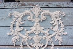 an ornate design is on the side of a wooden planked wall with blue paint