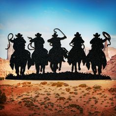 the silhouettes of four cowboys on horseback are shown in front of a desert landscape