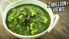 a white bowl filled with green soup on top of a wooden table