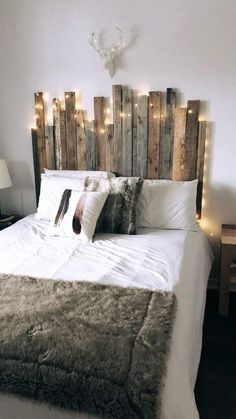 a bed made out of pallet wood with lights on the headboard and pillows