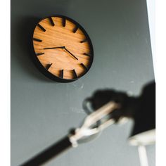 a wooden clock hanging on the wall next to a key