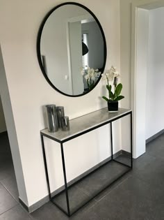 a mirror on the wall above a console table