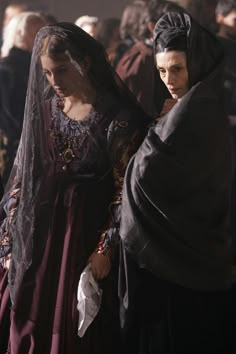 two people dressed in medieval clothing standing next to each other