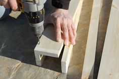 a person using a drill to cut wood