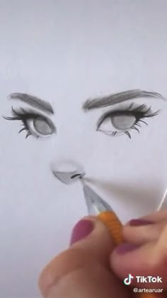 someone is drawing a woman's face with scissors