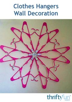 there is a pink wall decoration with scissors hanging from it's sides and the words, clothes hangers wall decoration