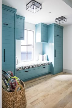 an empty room with blue cabinets and wooden floors