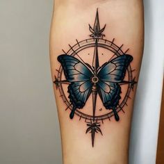 a blue butterfly sitting on top of a compass