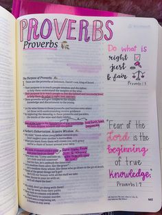 an open bible with proverbs written on the pages and in pink, purple, and green