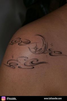 the back of a woman's shoulder with swirls and stars tattoo on it