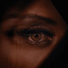 a person's eye is seen through the shadow of their face in this artistic photograph