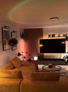 a living room filled with furniture and a flat screen tv mounted to the side of a wall