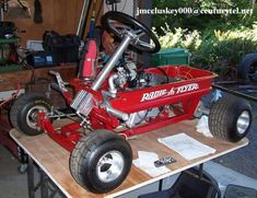 a small red cart sitting on top of a wooden table