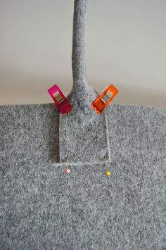 a pair of orange and pink earrings sitting on top of a gray carpeted floor