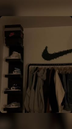 a closet filled with clothes and shoes next to a wall mounted shoe rack on the wall