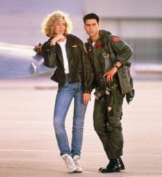 a man and woman standing next to an airplane