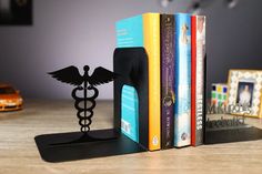 a bookend made out of books with a cadus symbol on it