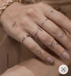 a woman's hand with three different tattoos on her fingers and the other finger