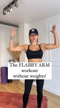 a woman standing on top of a yoga mat with her arms in the air