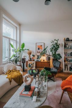 a living room filled with furniture and lots of plants