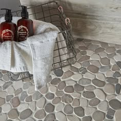 two bottles of hand sanitizers sit on a towel rack next to a basket